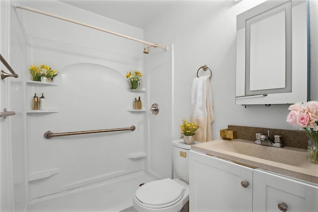 bathroom with toilet, vanity, and walk in shower