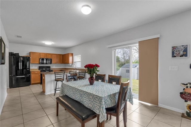 dining room featuring sink and light tile patterned floors