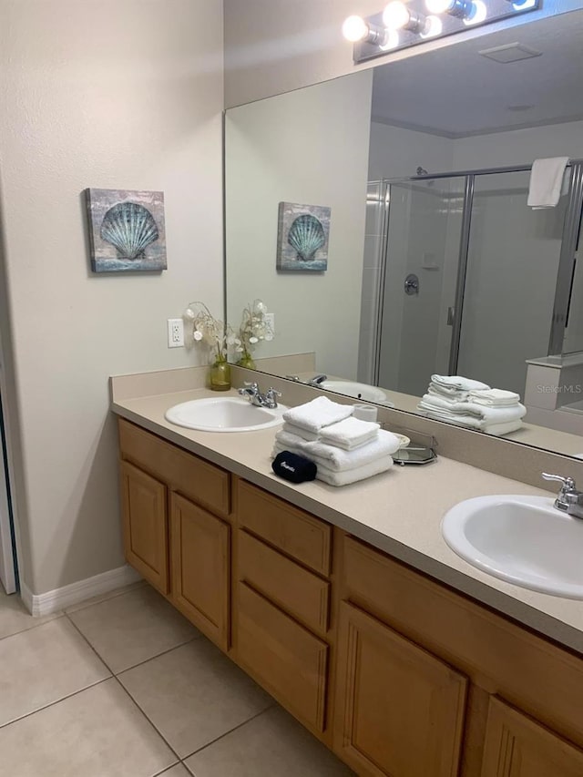 bathroom with tile patterned floors, a shower with door, and vanity