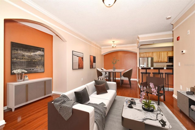 living room with crown molding, wood-type flooring, and a textured ceiling