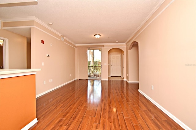 unfurnished living room featuring ornamental molding, wood-type flooring, and a textured ceiling