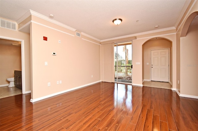 unfurnished room with hardwood / wood-style flooring, crown molding, and a textured ceiling