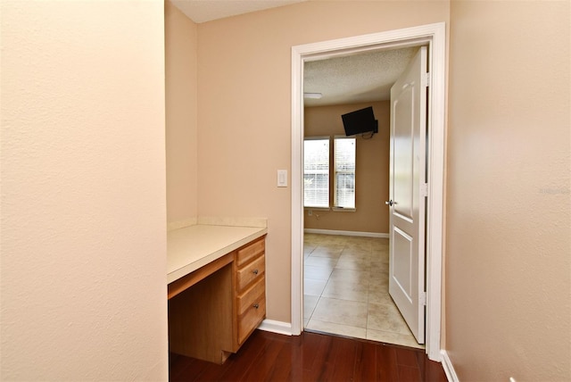 corridor featuring a textured ceiling and light wood-type flooring