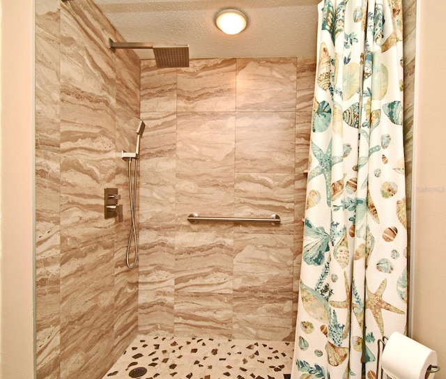 bathroom with a textured ceiling and a shower with shower curtain