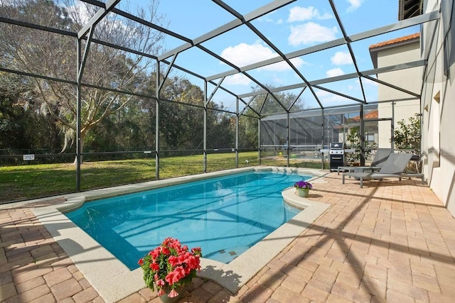 view of swimming pool featuring a patio, area for grilling, glass enclosure, and a lawn