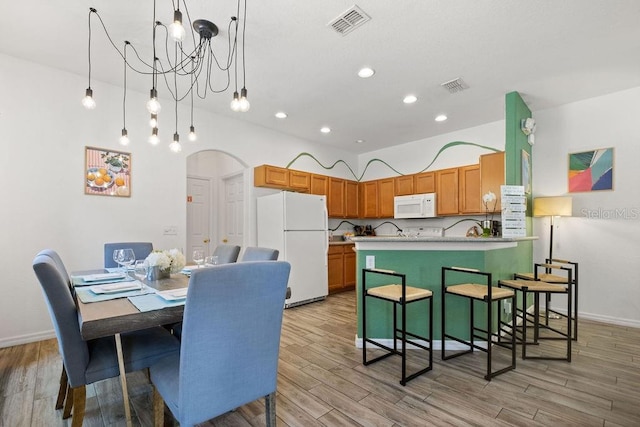 dining area with an inviting chandelier and light hardwood / wood-style floors