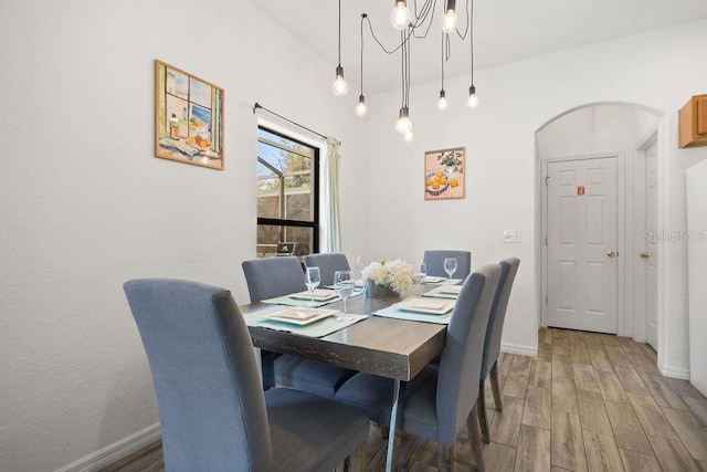 dining space featuring hardwood / wood-style flooring and a chandelier