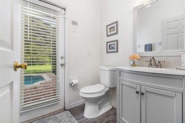 bathroom with tasteful backsplash, vanity, hardwood / wood-style flooring, and toilet