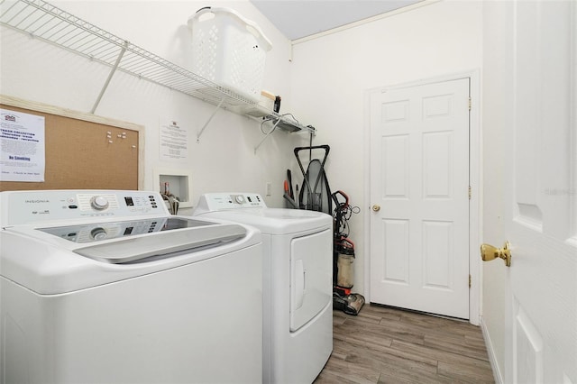 washroom with independent washer and dryer and light hardwood / wood-style flooring