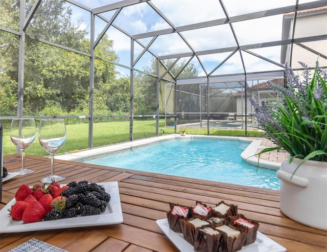 view of swimming pool featuring a lanai and a lawn