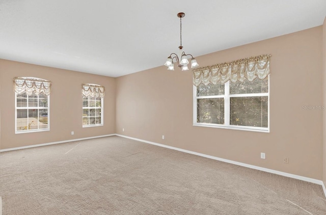 unfurnished room featuring an inviting chandelier and carpet