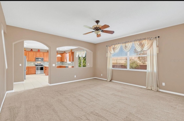 carpeted spare room with ceiling fan