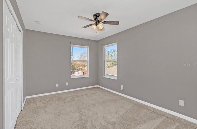 spare room featuring ceiling fan and light carpet