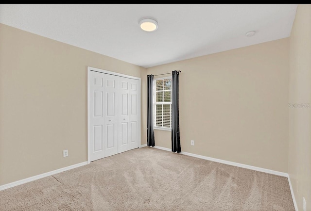 unfurnished bedroom with carpet floors and a closet