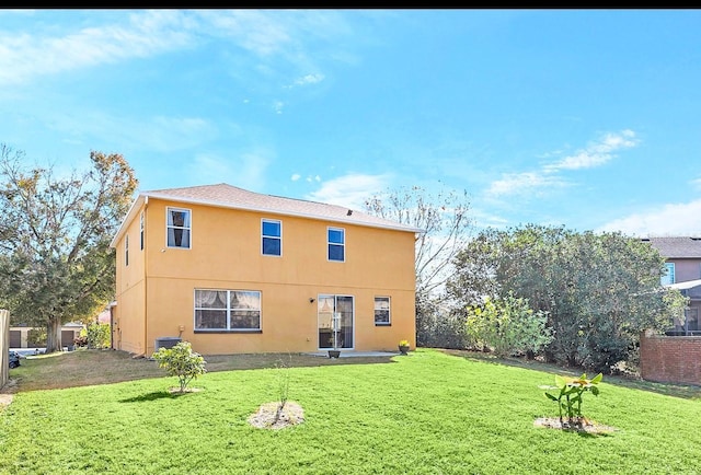 rear view of property with a lawn and central air condition unit