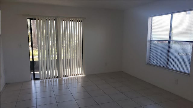 unfurnished room featuring light tile patterned flooring and plenty of natural light