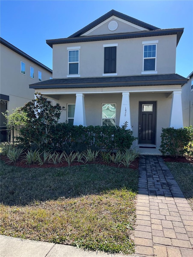 view of front facade with a front yard and covered porch