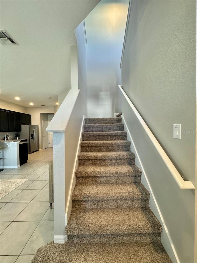 stairway with tile patterned floors