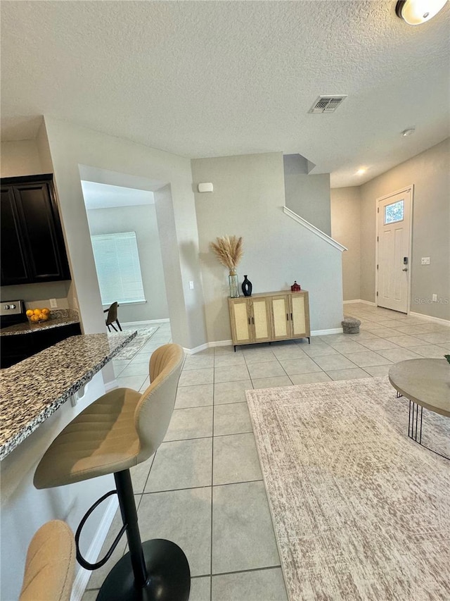 interior space featuring light tile patterned flooring and a textured ceiling