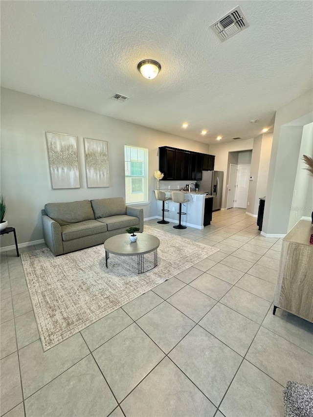 living room with light tile patterned floors and a textured ceiling