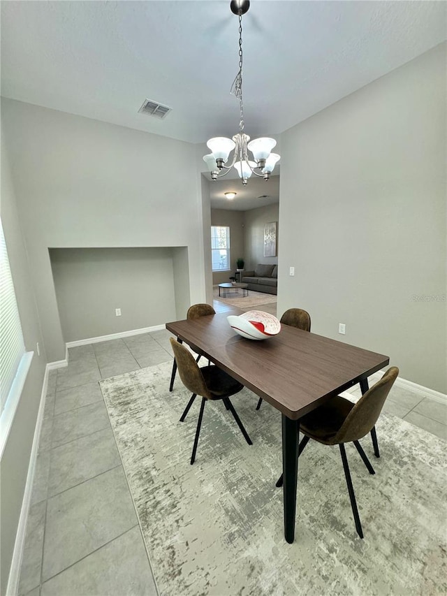 tiled dining room featuring an inviting chandelier