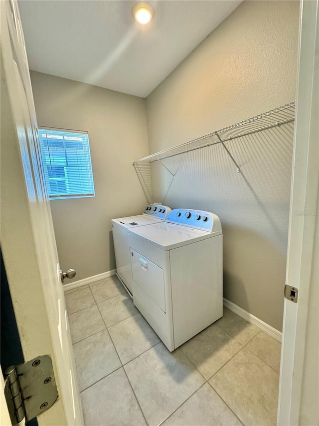 clothes washing area featuring washing machine and clothes dryer and light tile patterned flooring