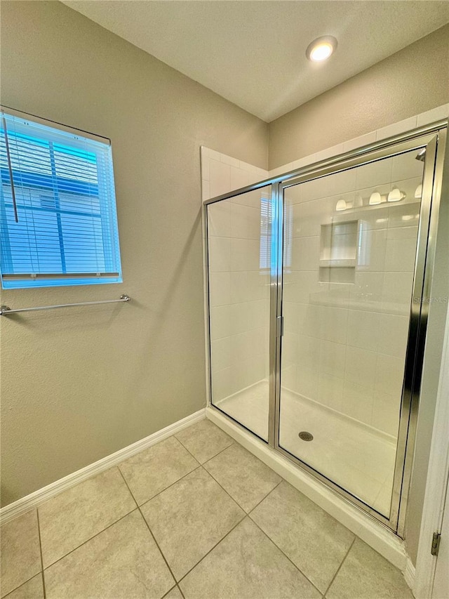 bathroom with tile patterned floors and a shower with shower door