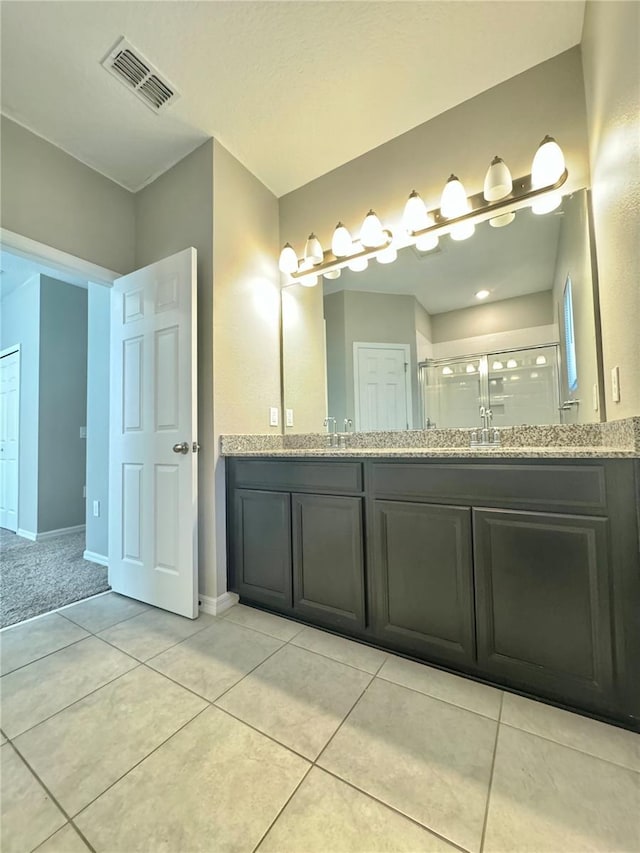 bathroom with tile patterned floors, a shower with shower door, and vanity