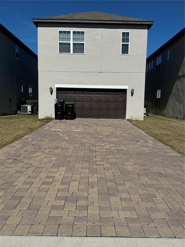 front of property with a garage and cooling unit