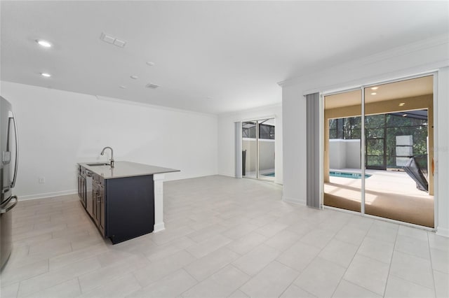 kitchen with crown molding, sink, and stainless steel refrigerator