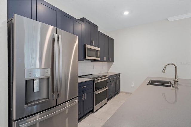 kitchen featuring appliances with stainless steel finishes, sink, decorative backsplash, and light tile patterned floors