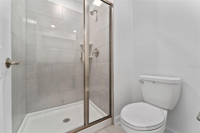 bathroom with tile patterned flooring, walk in shower, and toilet