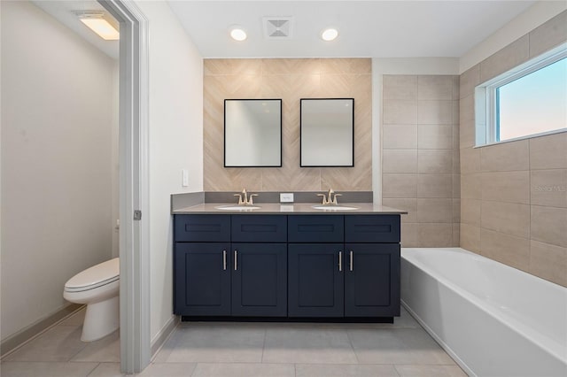 bathroom featuring a washtub, vanity, tile patterned flooring, and toilet