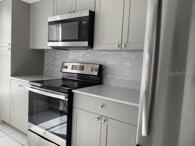 kitchen featuring tasteful backsplash, stainless steel appliances, and light tile patterned floors