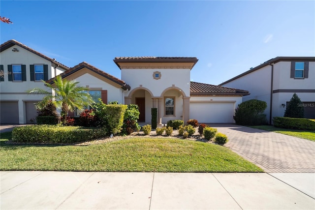 mediterranean / spanish house with a garage and a front yard