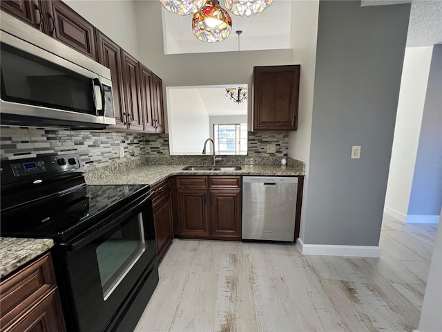 kitchen featuring tasteful backsplash, sink, stainless steel appliances, light stone countertops, and light hardwood / wood-style flooring