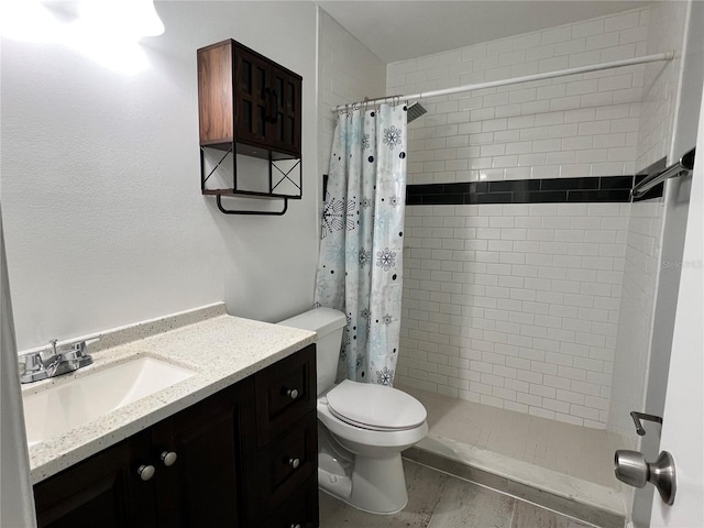 bathroom featuring vanity, walk in shower, and toilet