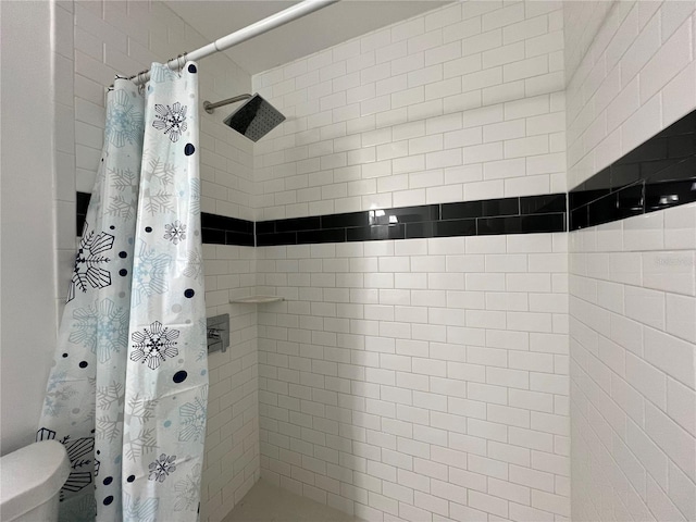 bathroom featuring curtained shower and toilet