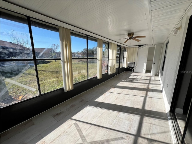 unfurnished sunroom featuring cooling unit and ceiling fan