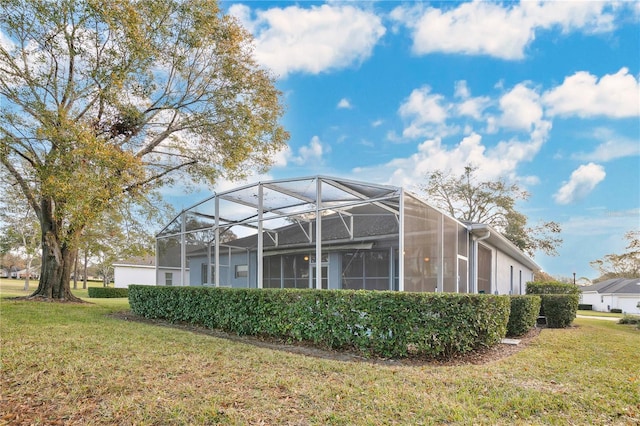 rear view of house with a yard and a lanai