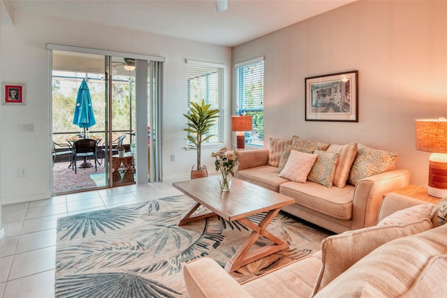 living room with light tile patterned flooring, ceiling fan, and a textured ceiling