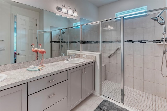 bathroom with a shower with door, vanity, and tile patterned floors