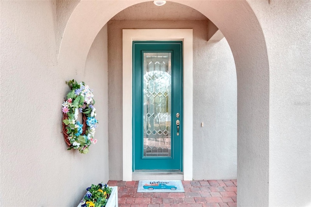 doorway to property featuring stucco siding