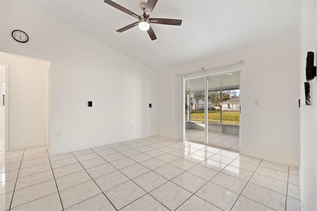 spare room with light tile patterned floors, vaulted ceiling, and ceiling fan