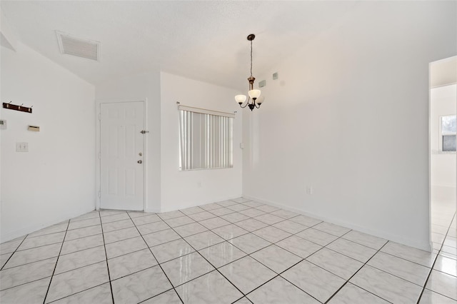 tiled empty room featuring a notable chandelier and vaulted ceiling