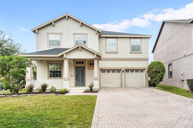 traditional-style home with decorative driveway, stucco siding, covered porch, an attached garage, and a front lawn