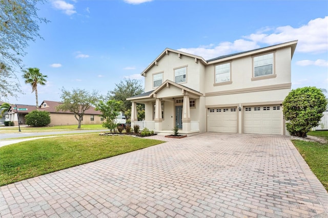 view of front facade with decorative driveway, stucco siding, covered porch, a front yard, and a garage