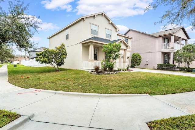 view of front of home featuring a balcony, a garage, driveway, stucco siding, and a front yard