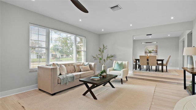 living room featuring ceiling fan and light hardwood / wood-style flooring