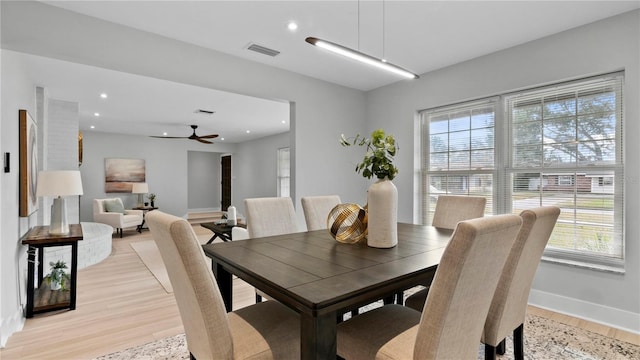 dining space with light hardwood / wood-style flooring and ceiling fan